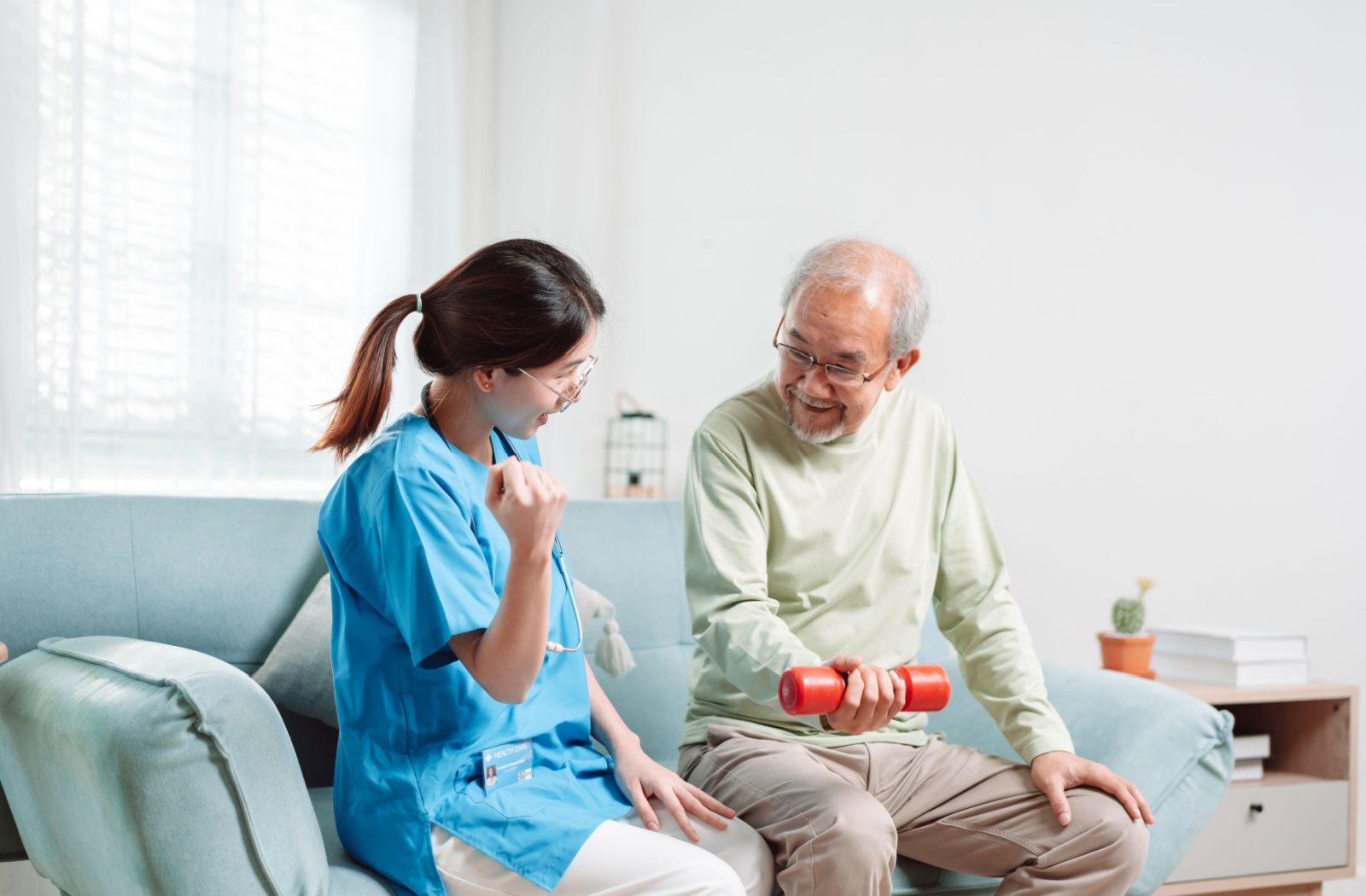 Older man exercising with help from caregiver.
